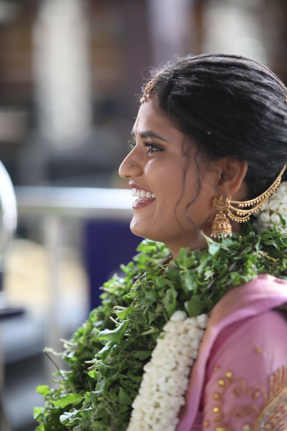 Makeup artist in Guruvayur - laughing bride in profile with jhumka and hair chain
