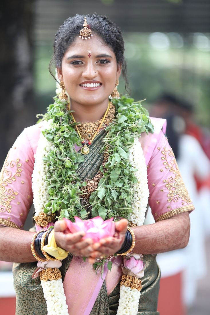 Guruvayur bridal makeup - bride holding a lotus with tulasi and jasmine garlands