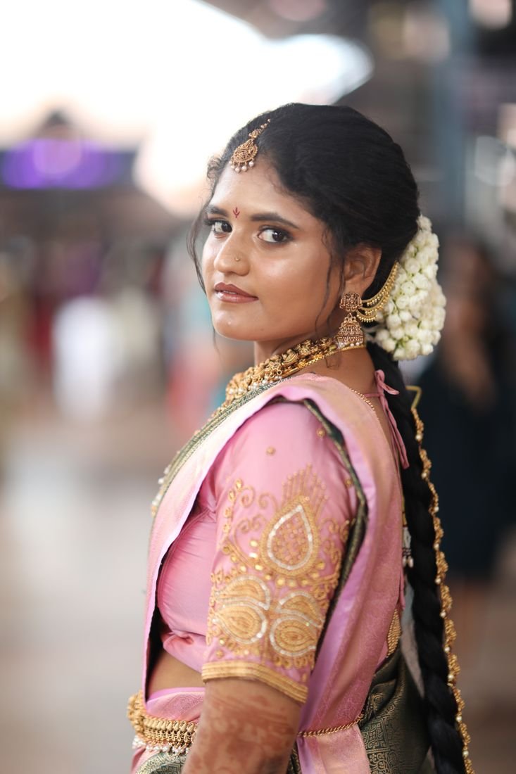 Bridal hair and makeup Guruvayur - bride in pink silk saree with jasmine bun and long braid