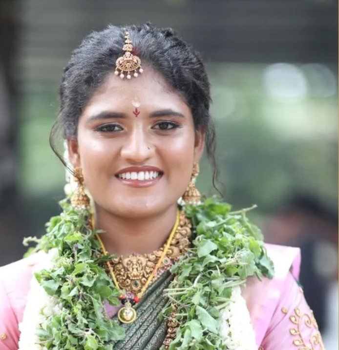 Bridal makeup Guruvayur - smiling bride in pink saree with tulasi and jasmine garland