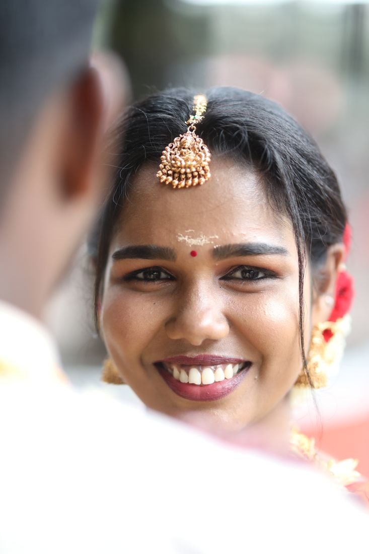 Guruvayur bridal makeup - smiling bride with maang tikka and kumkum
