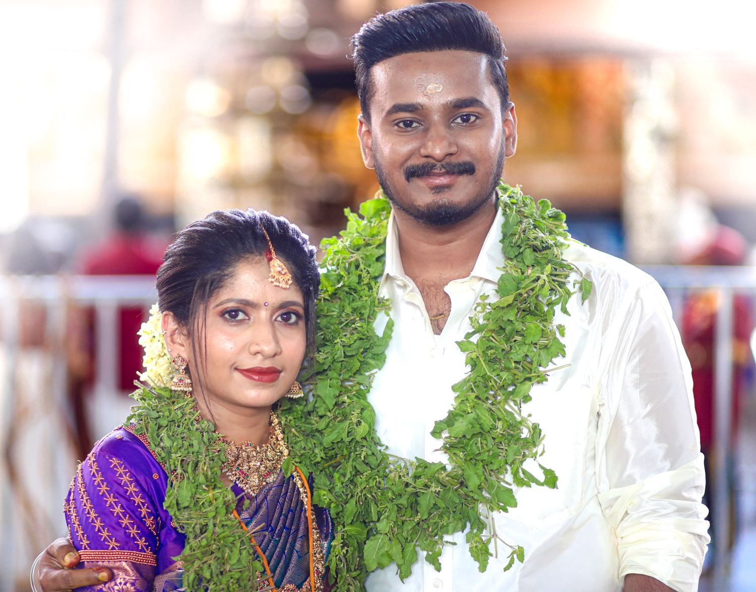 Guruvayur wedding makeup - bride and groom with tulasi garlands at the temple