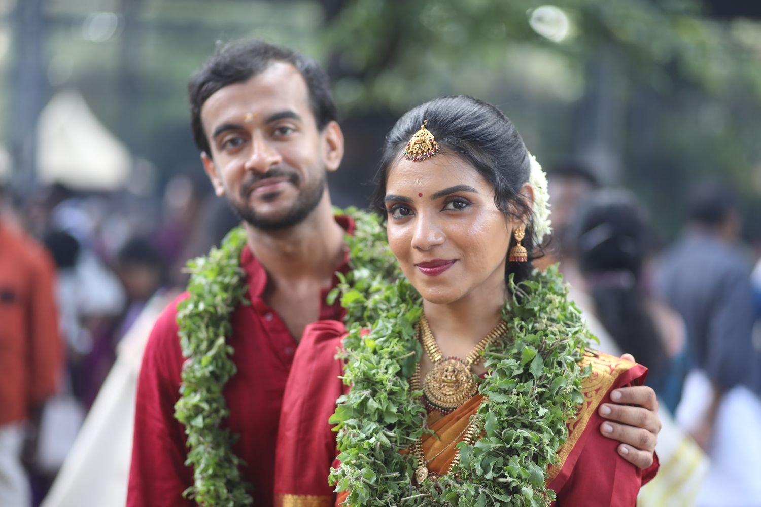 Guruvayur wedding makeup - bride and groom in red with tulasi garlands