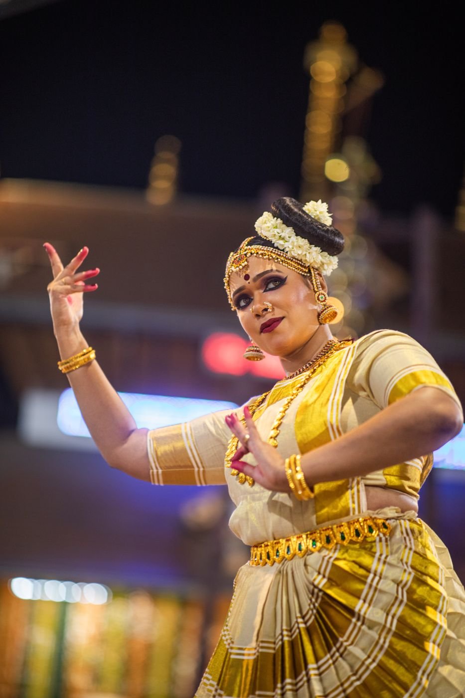 Guruvayur Mohiniyattam makeup - dancer mid-performance in cream and gold costume