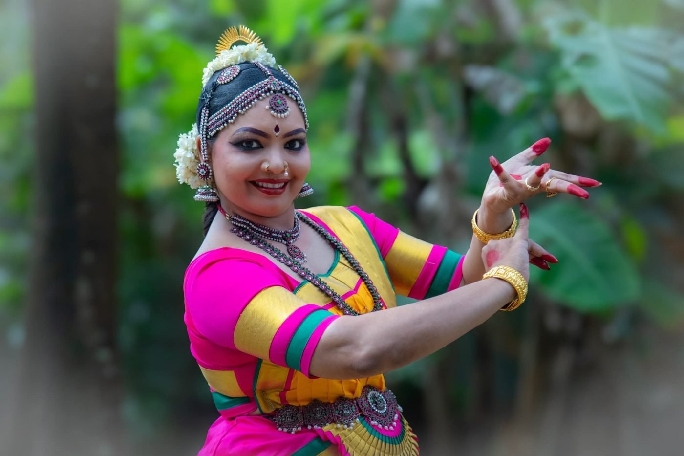 Bharatanatyam makeup Guruvayur - smiling dancer in pink and yellow silk with head ornament