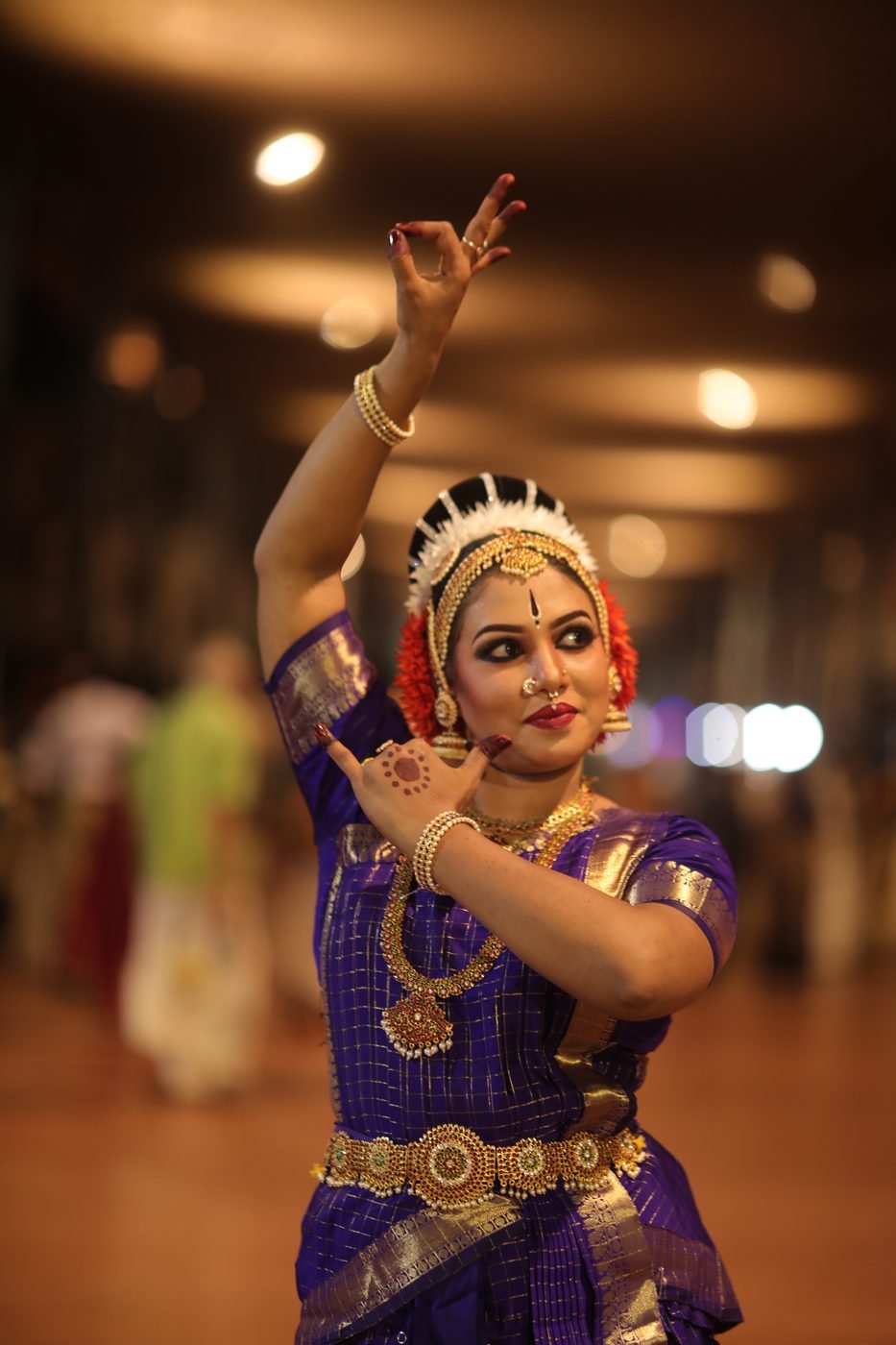 Bharatanatyam makeup Guruvayur - dancer in purple silk with jasmine and orange flowers in hair